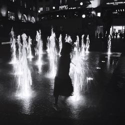 Reflection of people in water at night