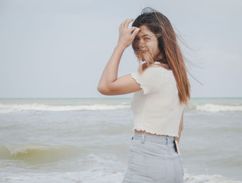 Side view of woman standing at beach