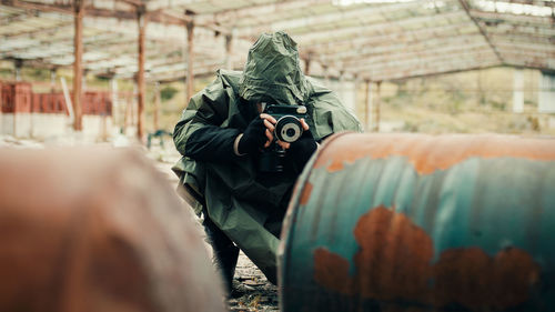 Man with gas mask photographs the radioactive barrels