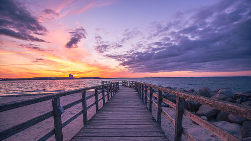 Pier over sea against sky during sunset