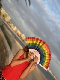 Midsection of woman holding umbrella against sky