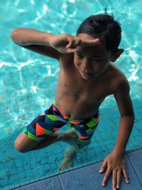 High angle view of shirtless man swimming in pool