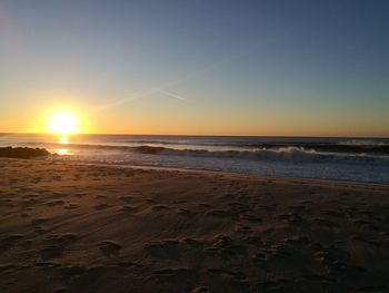 Scenic view of beach against sky during sunset