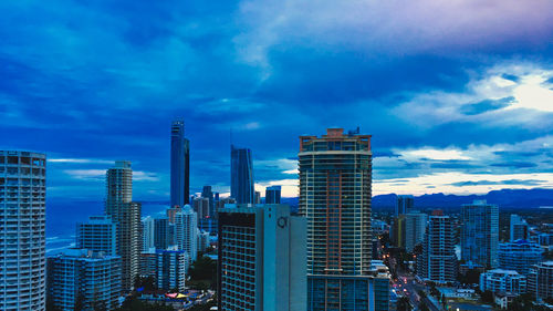 Modern buildings in city against blue sky