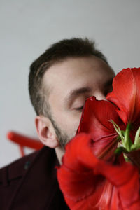 Close-up of young man with red rose