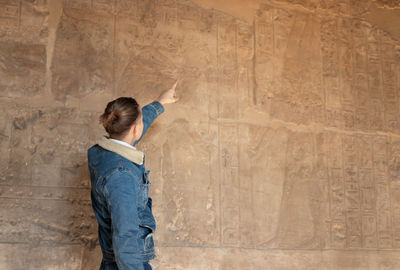 Unrecognizable tourist young man pointing and admiring the ancient and historical temple