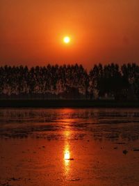 Scenic view of lake against orange sky
