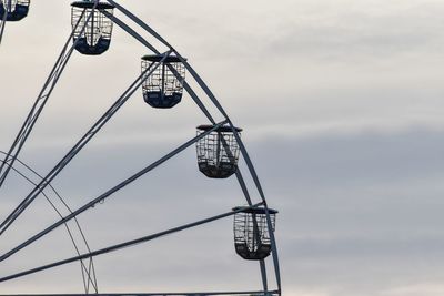 Low angle view of crane hanging against sky