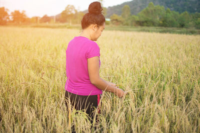 Side view of woman standing in field