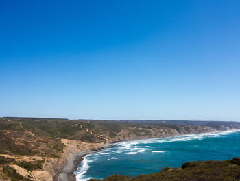 Scenic view of sea against clear blue sky