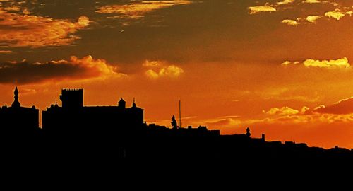 Silhouette buildings against sky during sunset