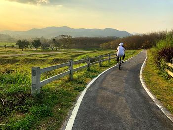 Rear view of man on field against sky