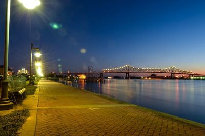 Illuminated street by river