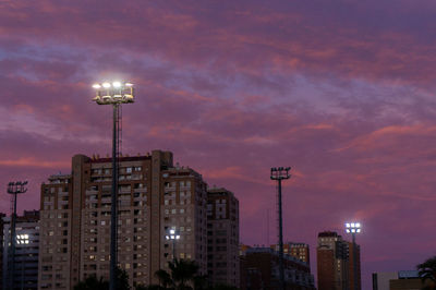 Low angle view of illuminated buildings against sky during sunset