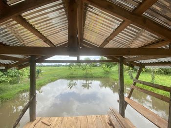 Scenic view of lake seen through wooden ceiling