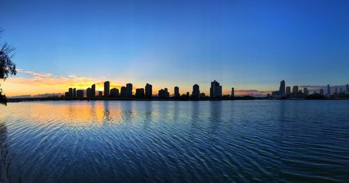 City at waterfront during sunset
