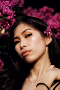 Close-up portrait of beautiful woman with pink flower