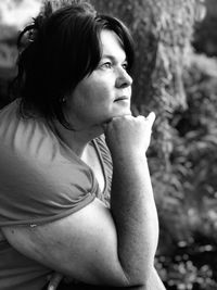 Side view of thoughtful mature woman looking away while sitting outdoors