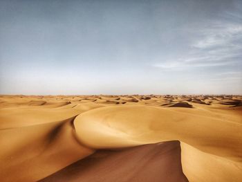 Sand dunes in desert against sky