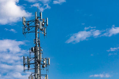 Low angle view of communications tower against blue sky