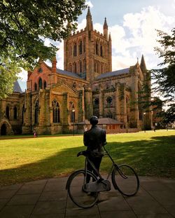 Rear view of man cycling against sky