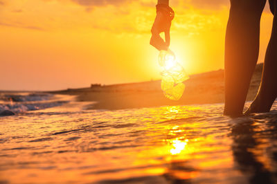 Low section of woman standing in sea