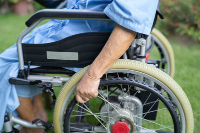 Midsection of man sitting on wheelchair