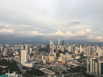 View of cityscape against cloudy sky