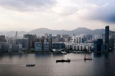 Boats in sea against buildings in city