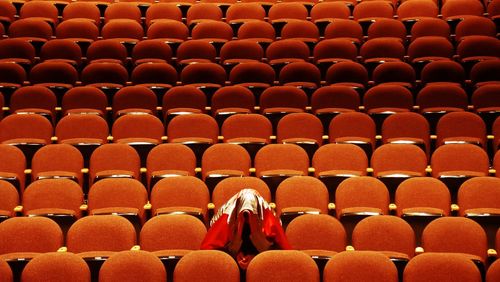 Person wearing scarf while sitting at auditorium