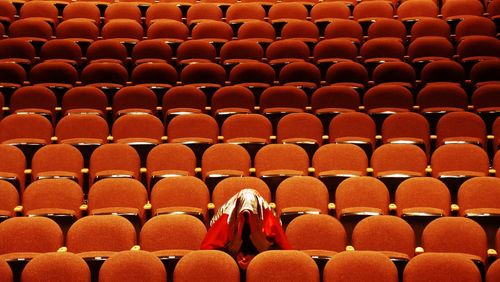 Person wearing scarf while sitting at auditorium