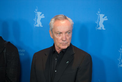 Portrait of man standing against blue background