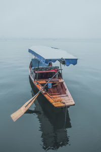 Ship moored on sea against sky