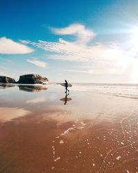 Silhouette of man with surfboard on beach