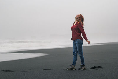 Joyful woman on empty black beach scenic photography