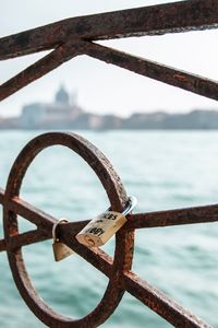 Close-up of rusty chain on sea against sky