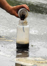 Close-up of person holding bottle on table