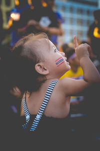 Close-up of cute girl with flag painting on cheek in city