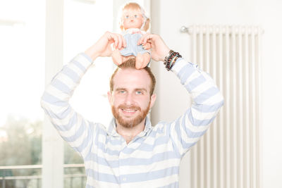 Portrait of smiling man standing against the wall