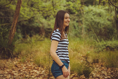 Young woman standing in forest