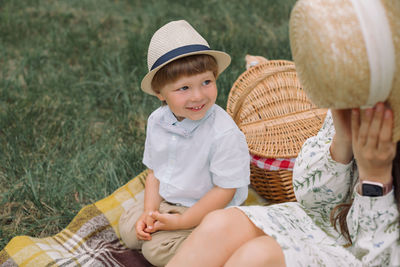 Portrait of happy little boy playing with his mother n in the park. family picnic concept.