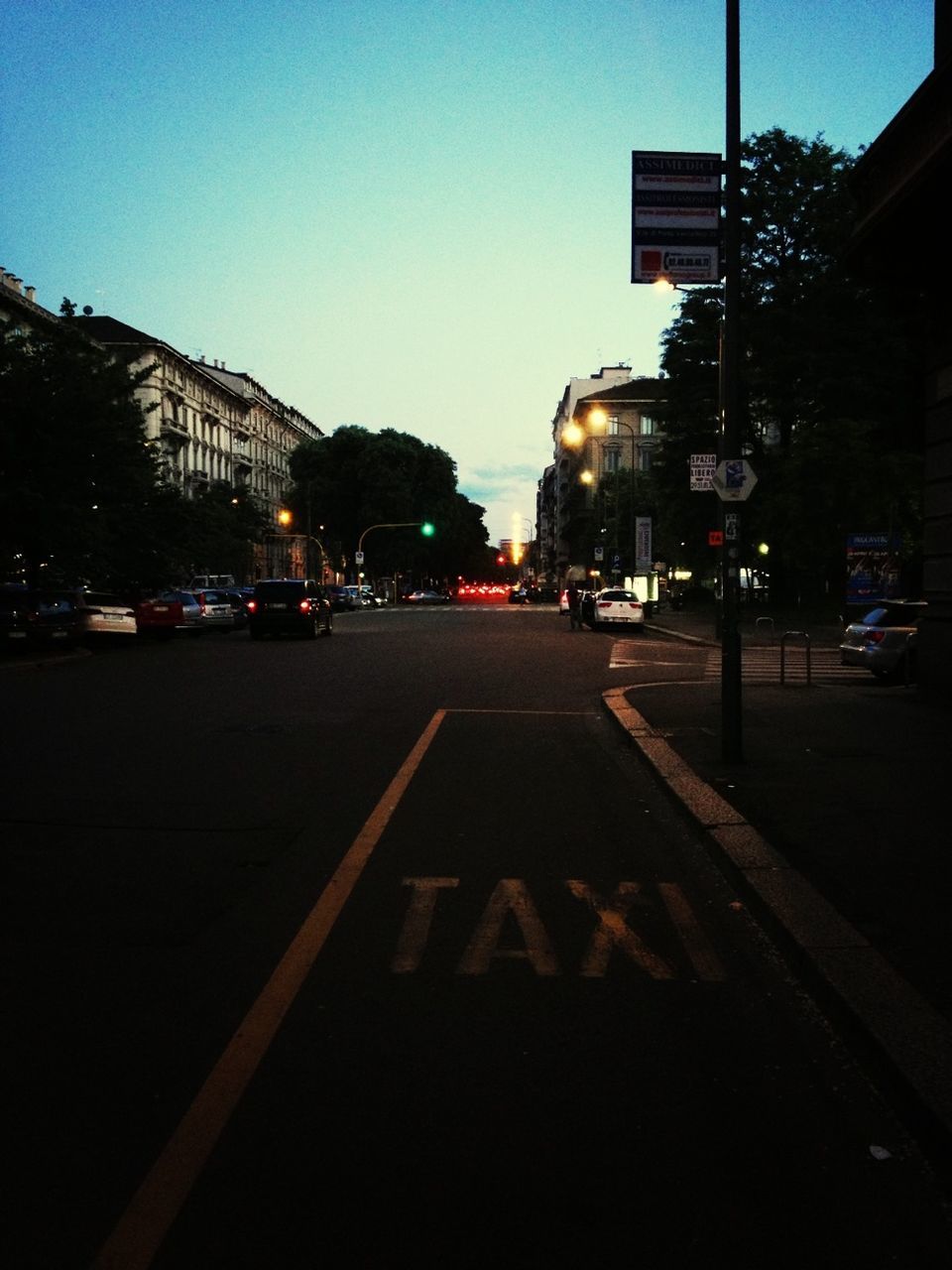 building exterior, illuminated, architecture, city, built structure, night, street, clear sky, road marking, road, transportation, street light, the way forward, city street, city life, dusk, car, sky, outdoors, lighting equipment