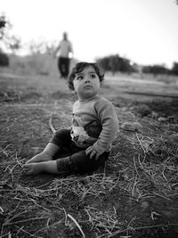 Cute baby girl sitting on land