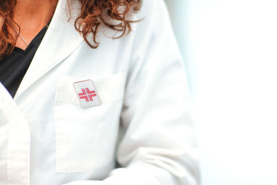 Woman doctor detail dil white lab coat with order pin