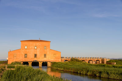 Arch bridge over river against buildings