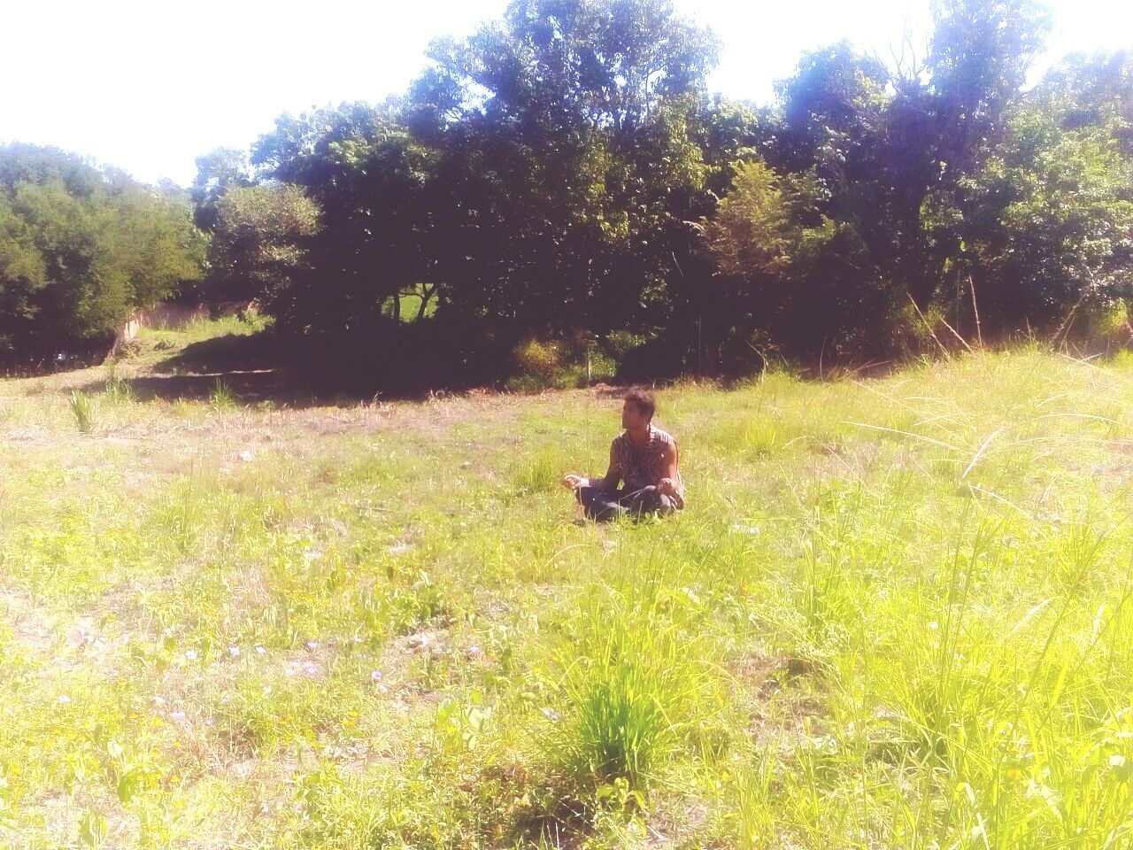 MAN RELAXING ON GRASSY FIELD