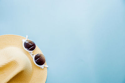 Hat and sunglasses on blue background