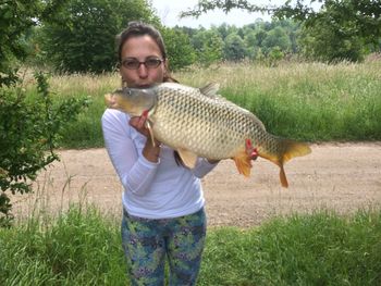 Portrait of mature woman holding dead fish while standing on land