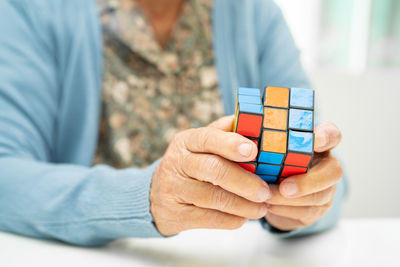 Midsection of man holding toy blocks on table