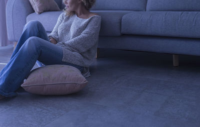 Young woman sitting on sofa at home